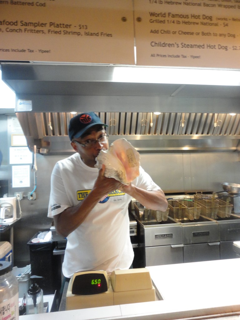 The owner of the Conch Shack humoring me by posing for a photo, conch shell and all