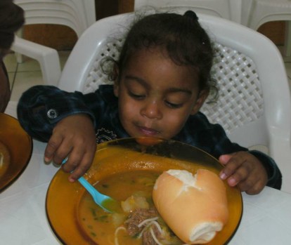 A cutie-pie enjoying the soup